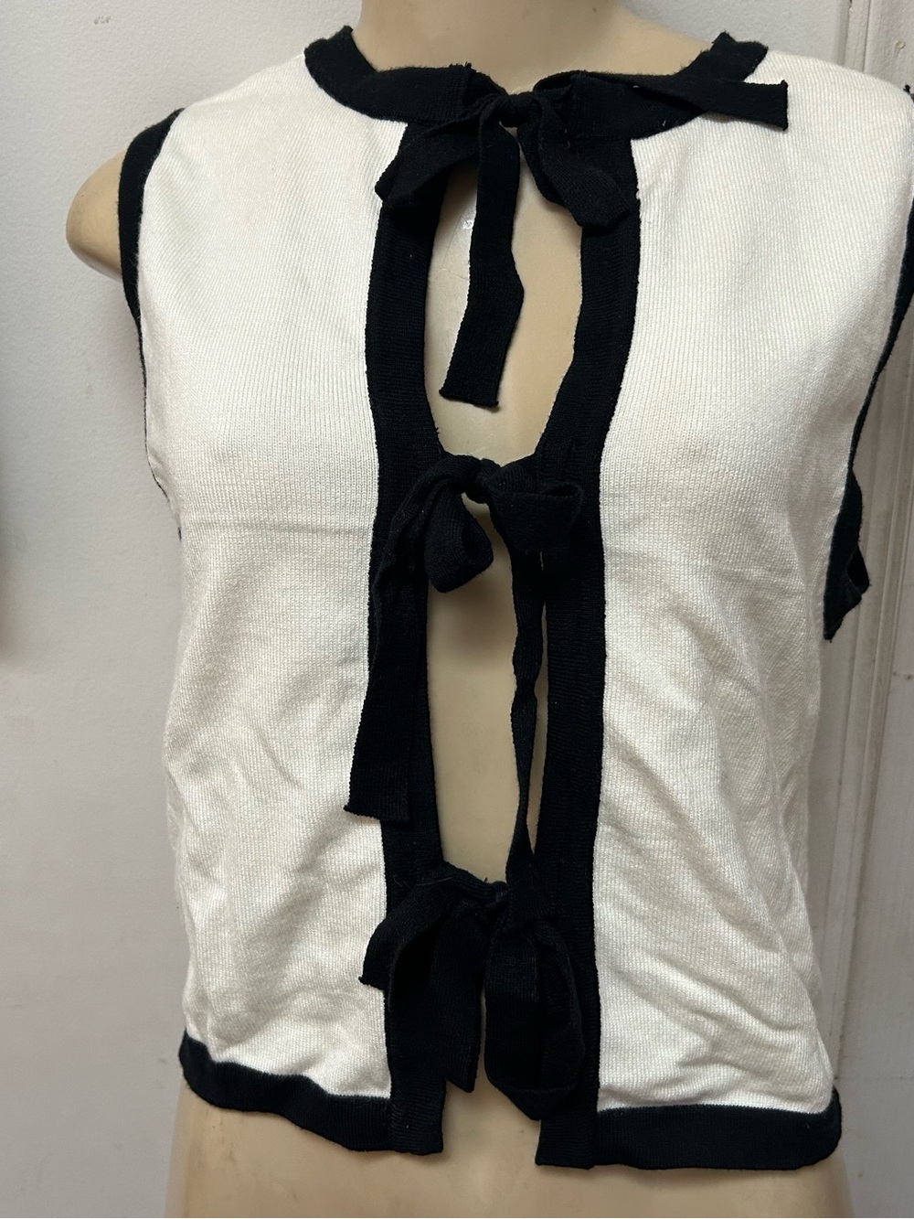 Sleeveless White Knit Top with Black Trim and Front Tie Details